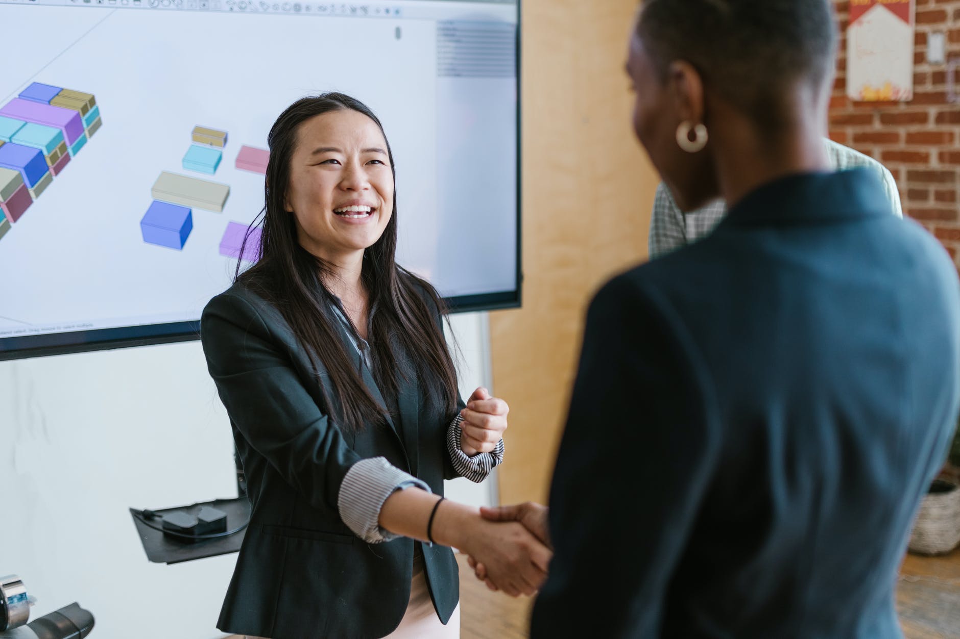 two woman shake hands in agreement