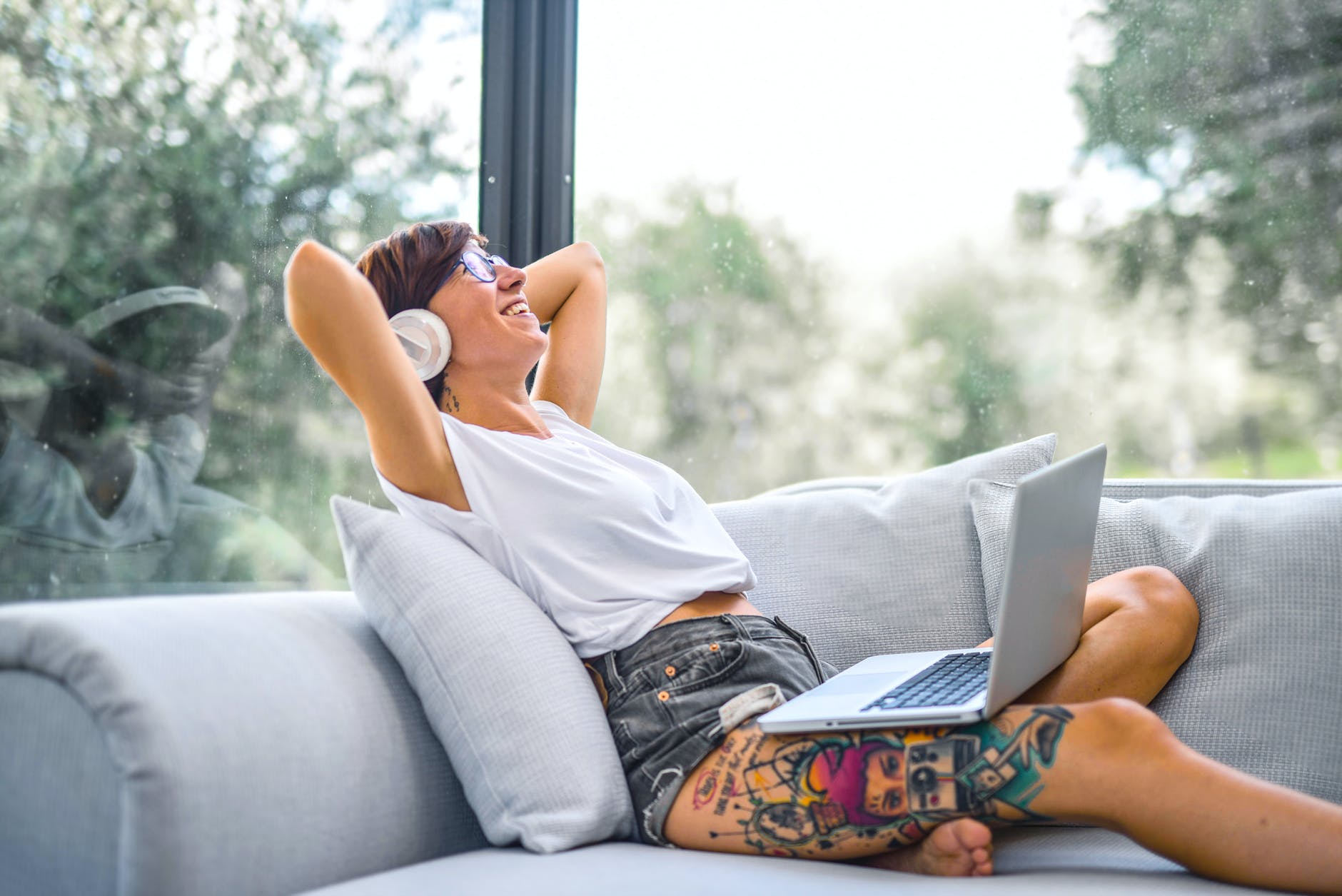 Woman wearing a headphone sitting on a couch